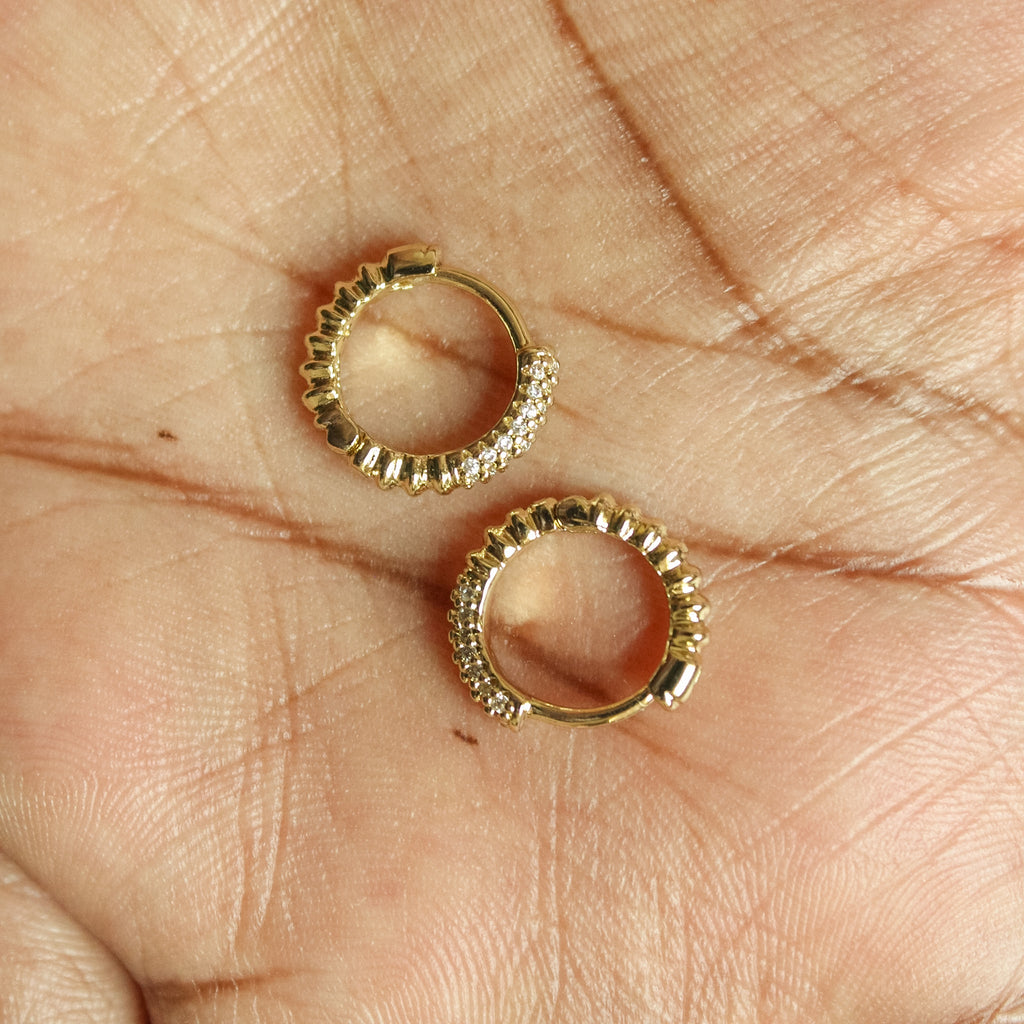 Dainty Pavé CZ Huggie Hoop Earrings Gold — pair in palm top-down view