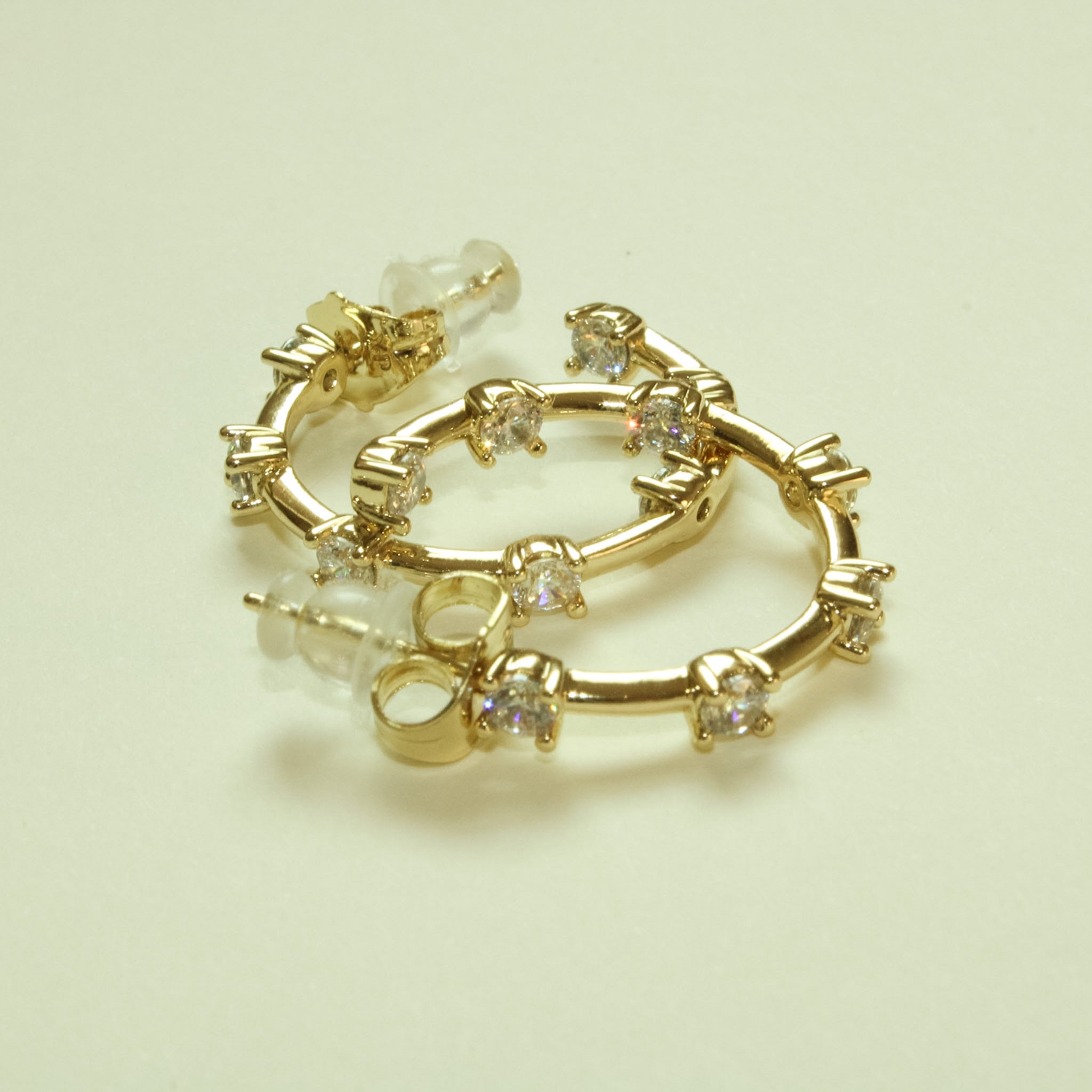 Gold open hoop earrings with round CZ stations and tiny clear accents