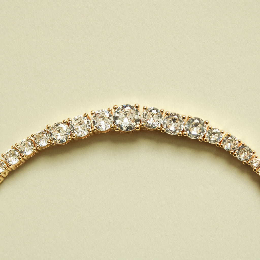 Graduated tennis bracelet with clear crystal stones in curved arc