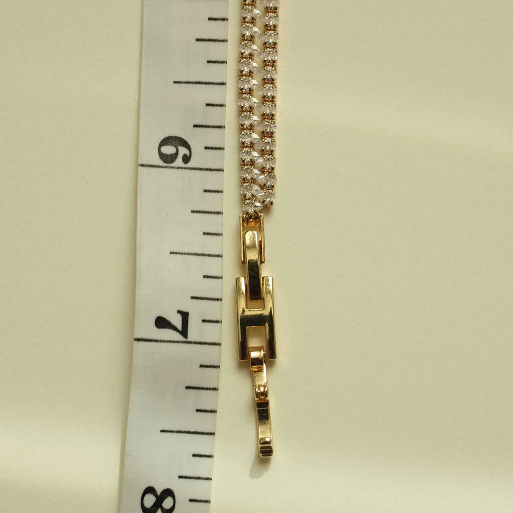Gold-tone double-row tennis bracelet clasp with clear CZ pavé, side view.