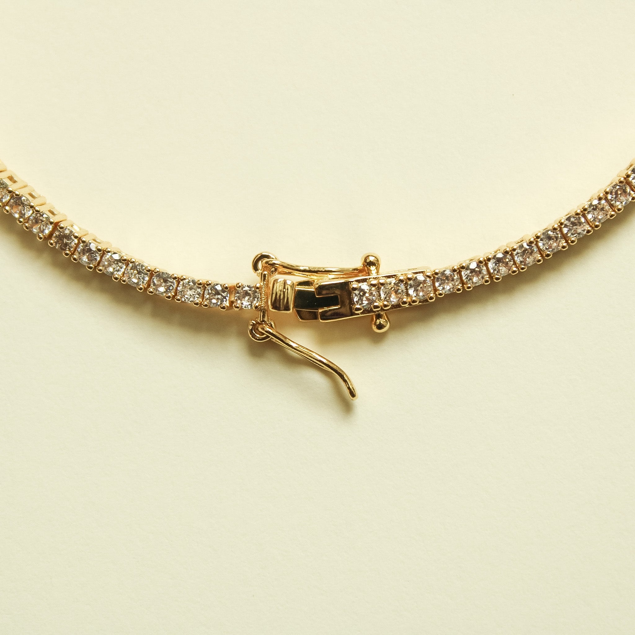 Gold-tone tennis bracelet clasp with pin-and-toggle and clear crystal stones