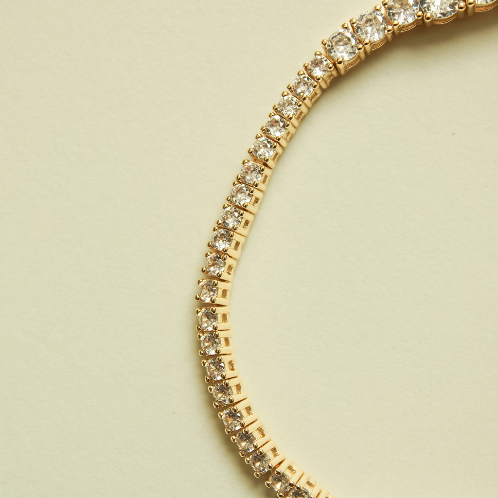Gold-tone graduated tennis bracelet with clear crystal stones row