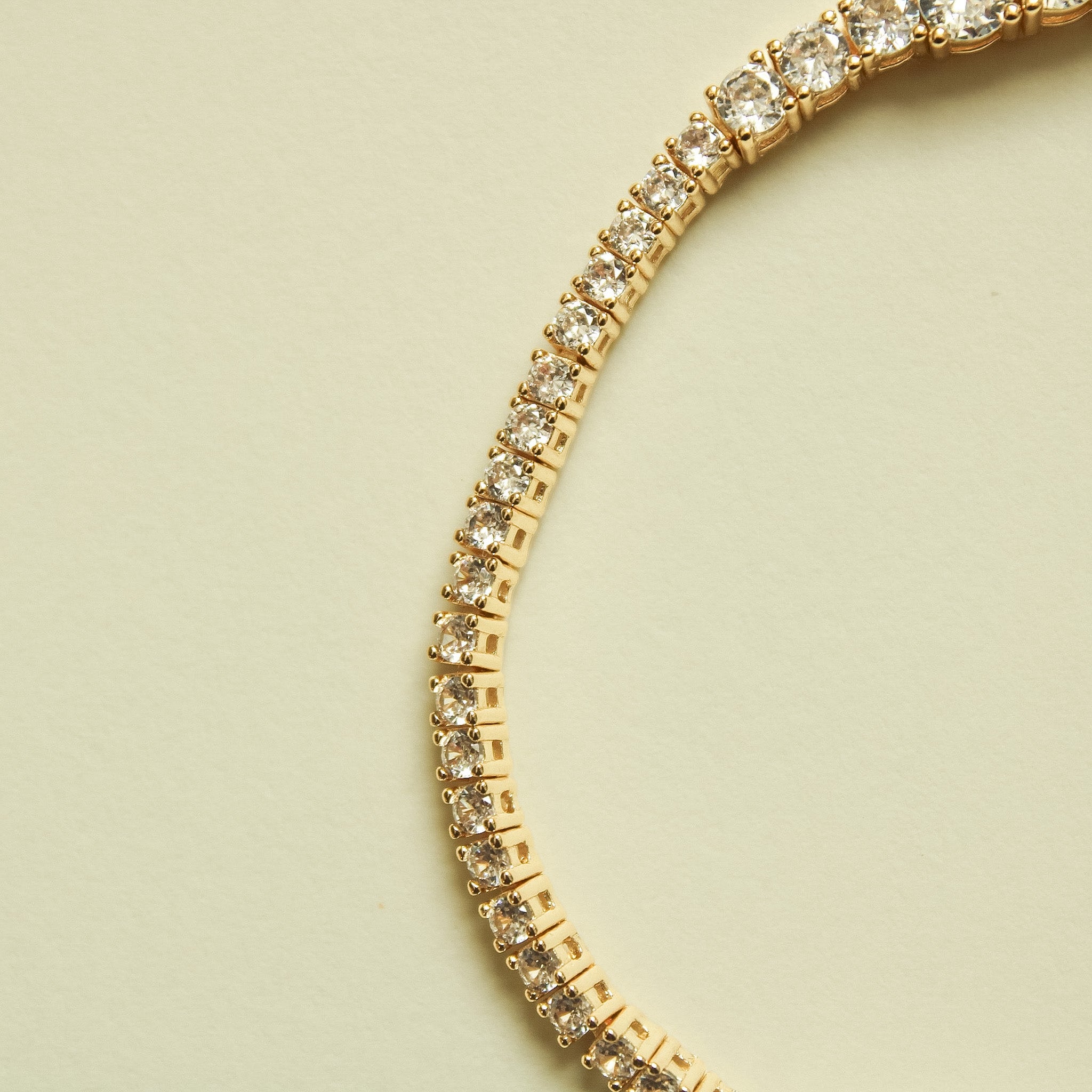 Gold-tone graduated tennis bracelet with clear crystal stones row