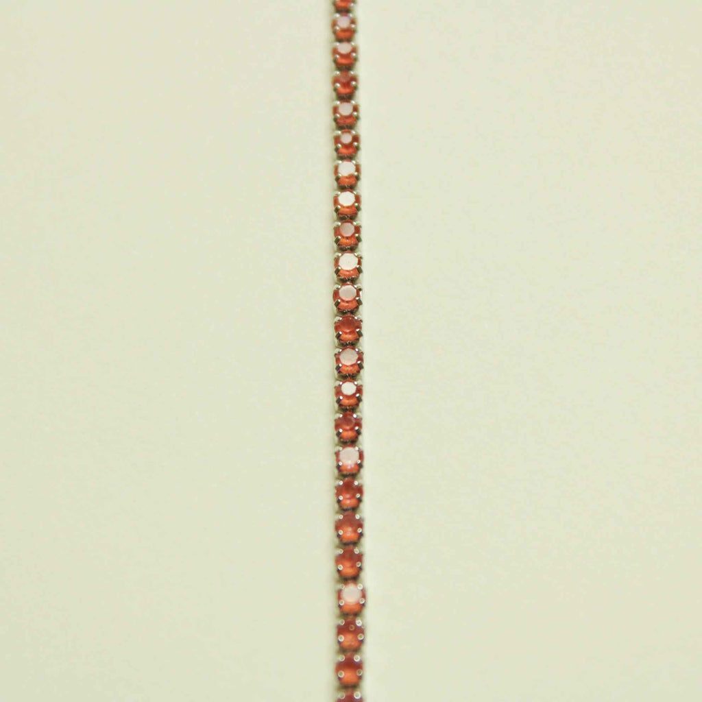 Color-shifting coral tennis bracelet with small round, tennis-set stones in rows