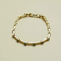 Gold-tone bar link bracelet with small square green accent stones