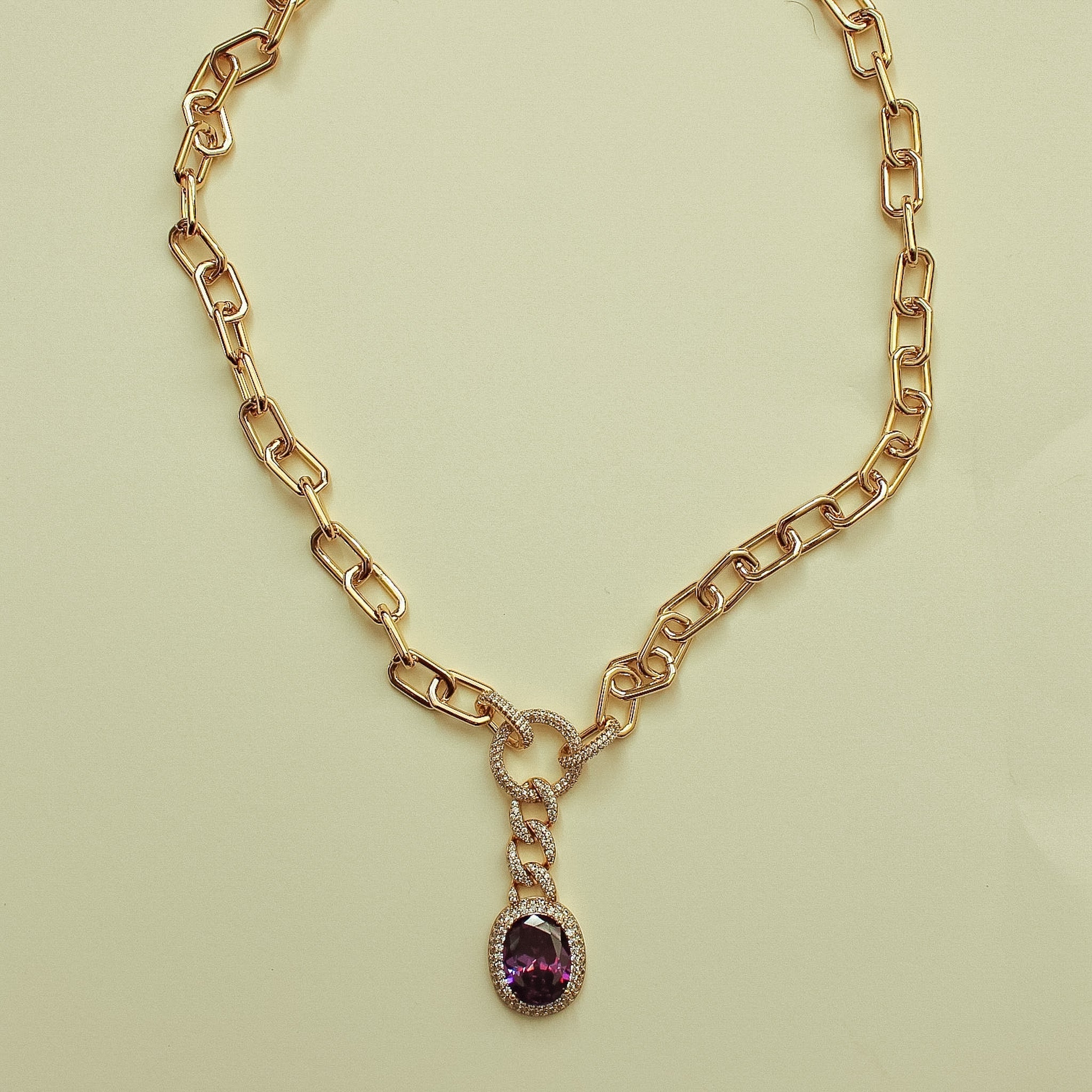 Gold paperclip chain necklace with purple gemstone drop pendant and crystal loop