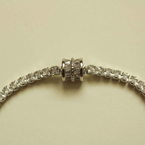 Silver tennis bracelet center with round clear stones and ridged barrel link