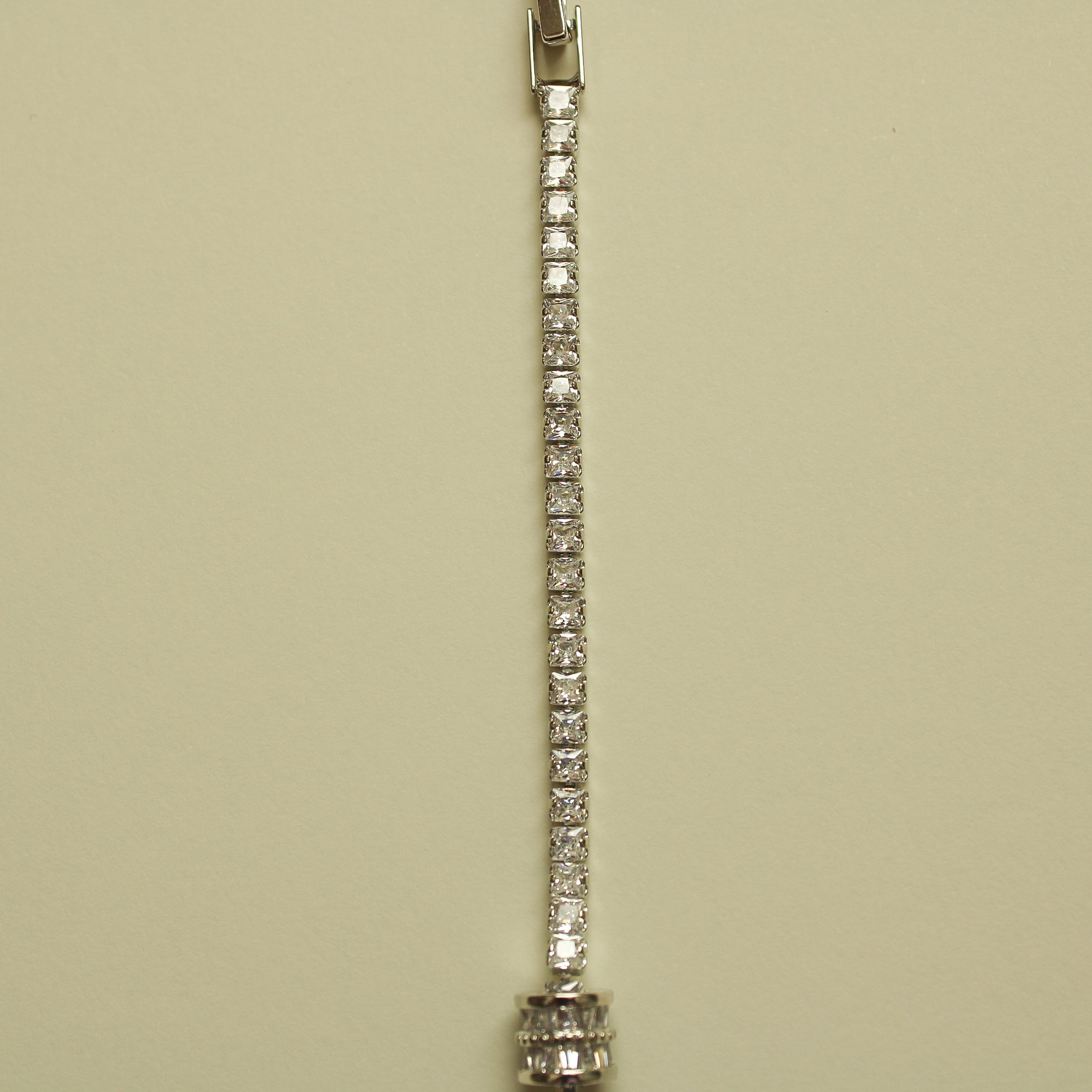 Silver tennis bracelet with continuous row of round clear stones and small end caps