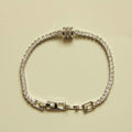 Silver tennis bracelet with round clear stones and baguette station links, box clasp