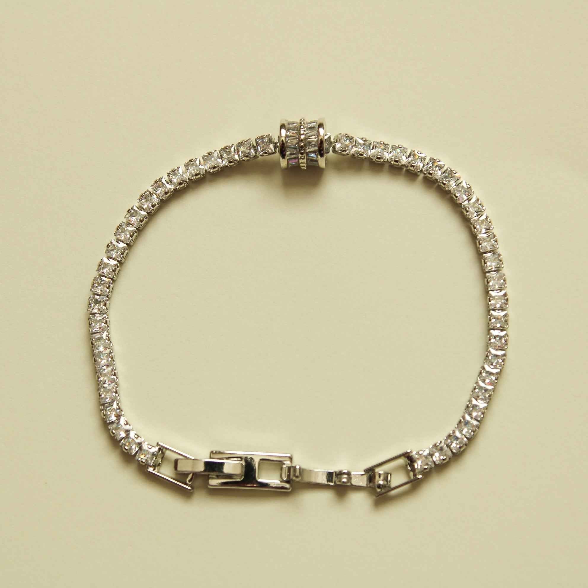 Silver tennis bracelet with round clear stones and baguette station links, box clasp