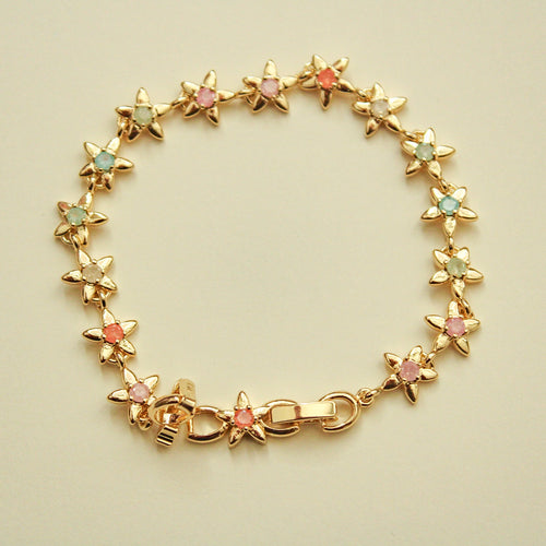 Gold flower charm bracelet with colorful stones and round link clasp.