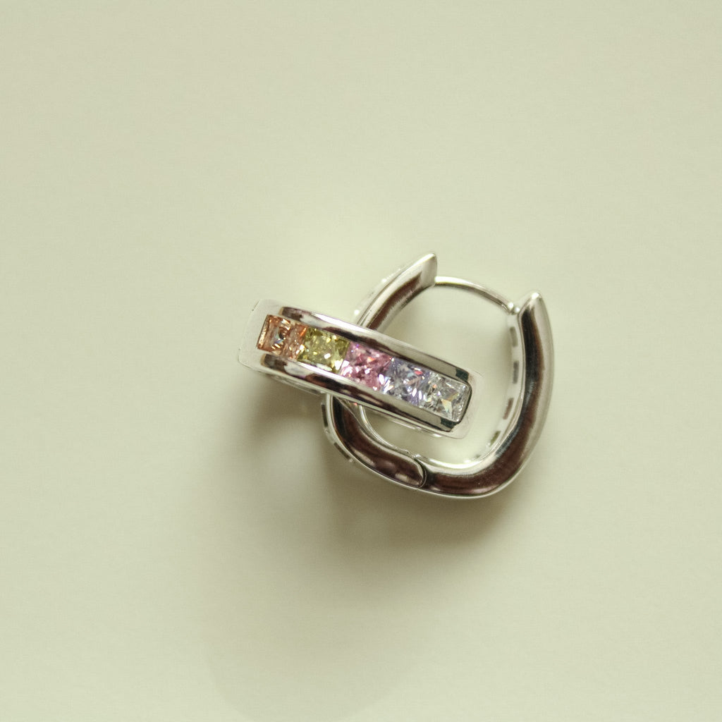 Silver hoop huggie earring with pink and clear rectangular stones, side view