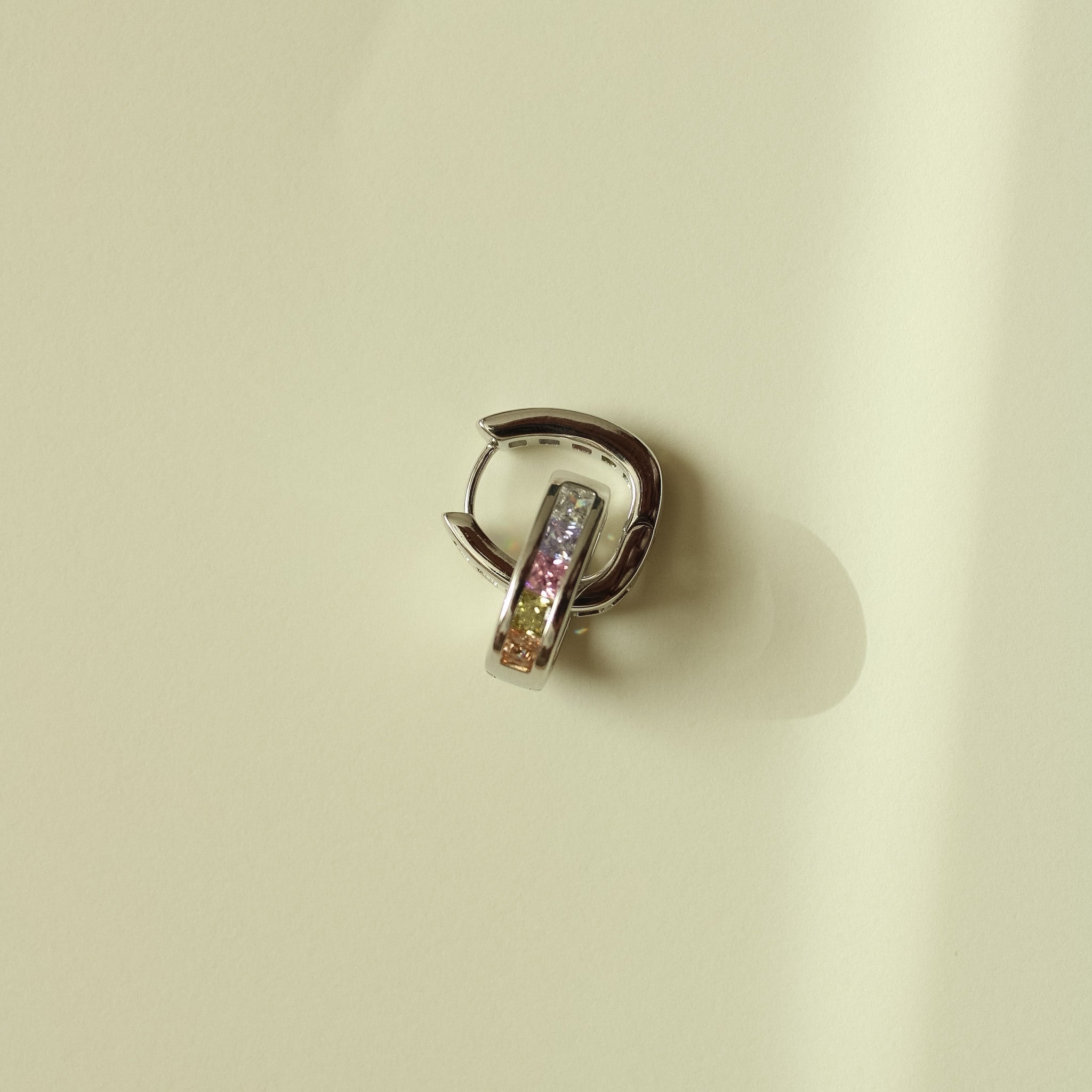 Silver hoop huggie earring with clear stone bar, back view