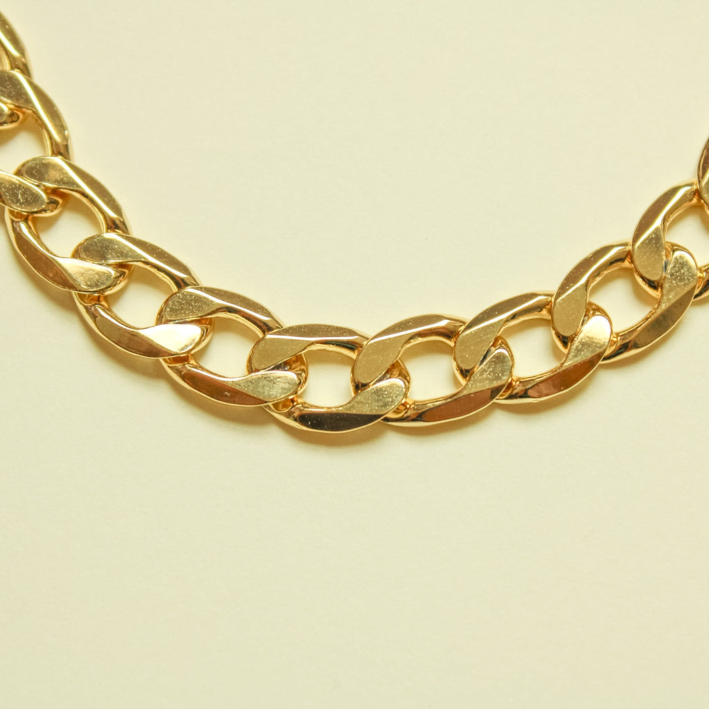 Chunky Cuban link 14K gold chain necklace, close-up of curved polished links