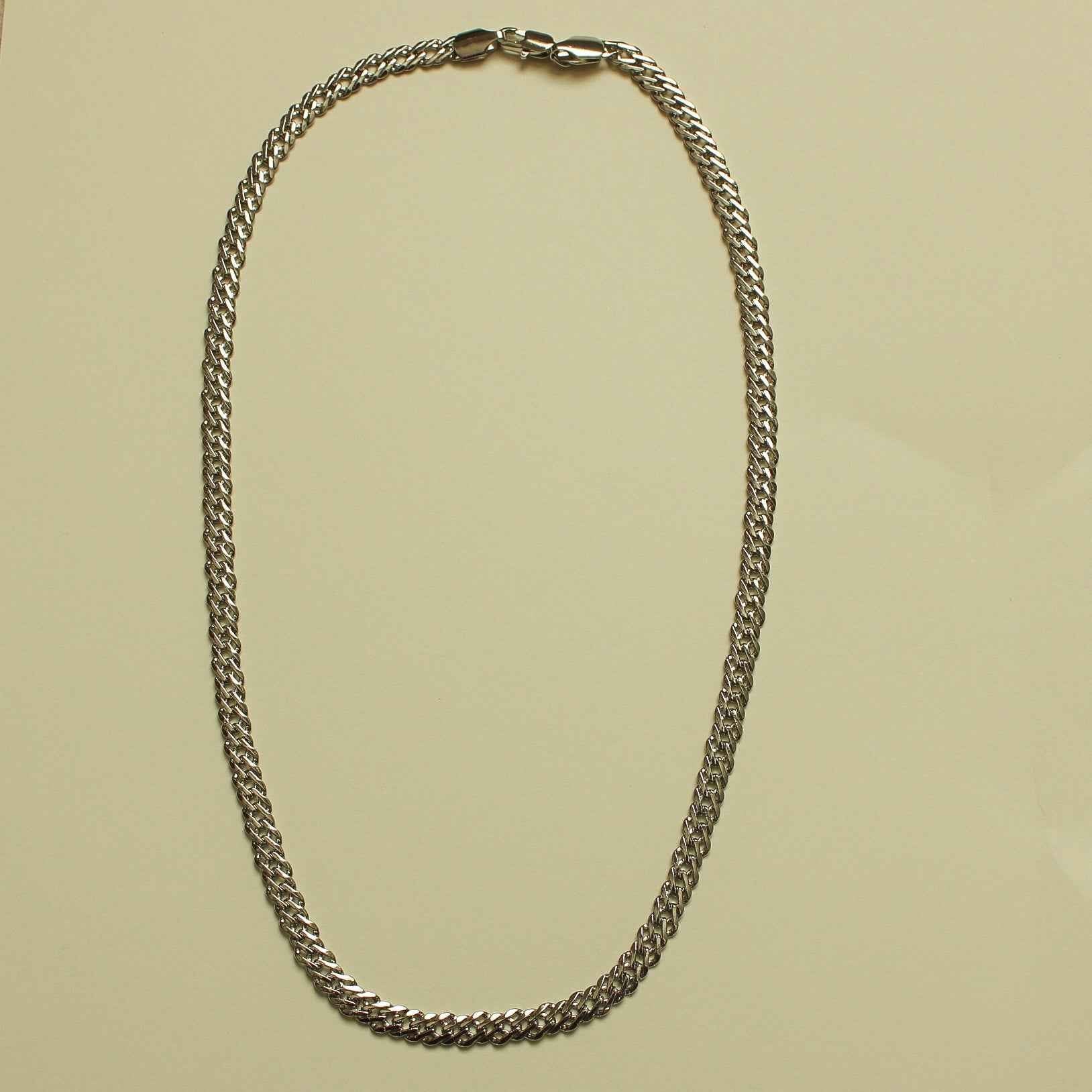 Chunky curb chain necklace arranged in an even loop of silver-tone links