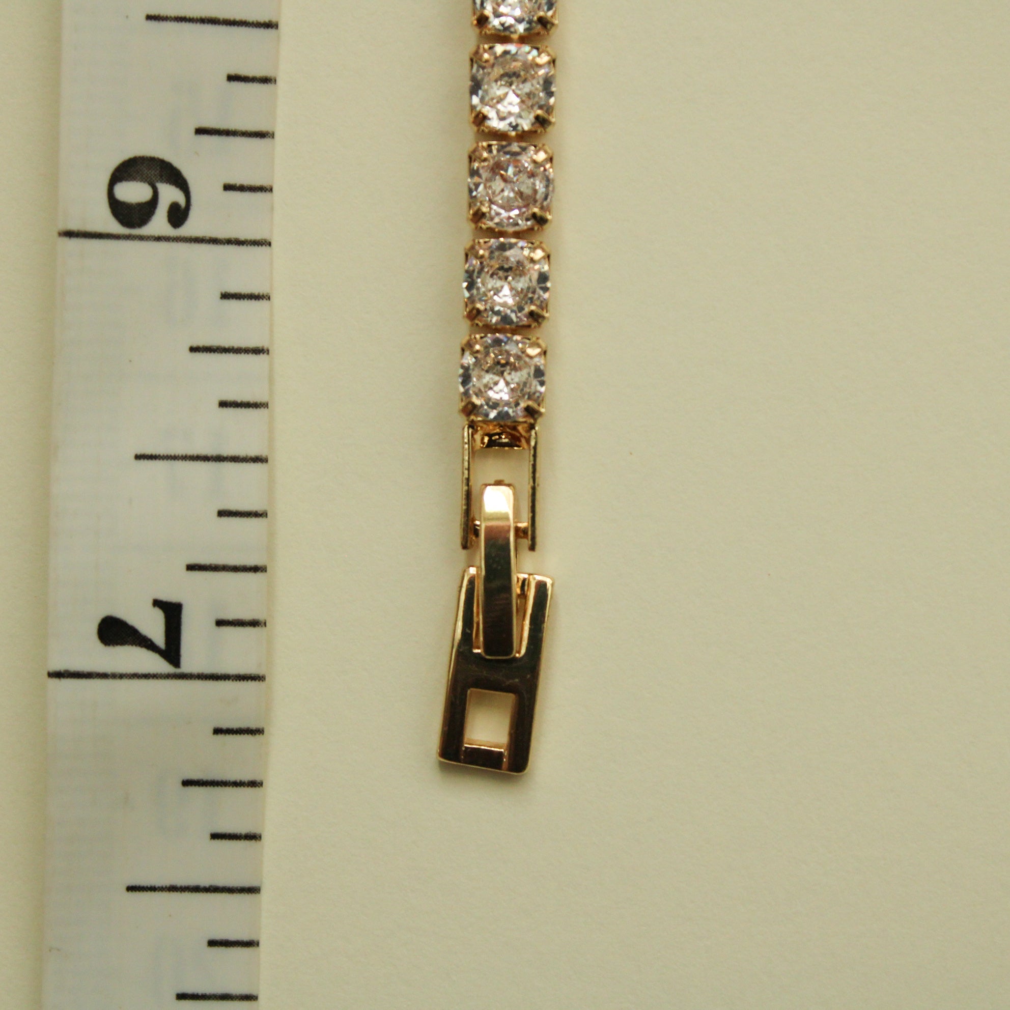 Gold-tone tennis bracelet clasp with clear CZ bezel stones and hinge closure