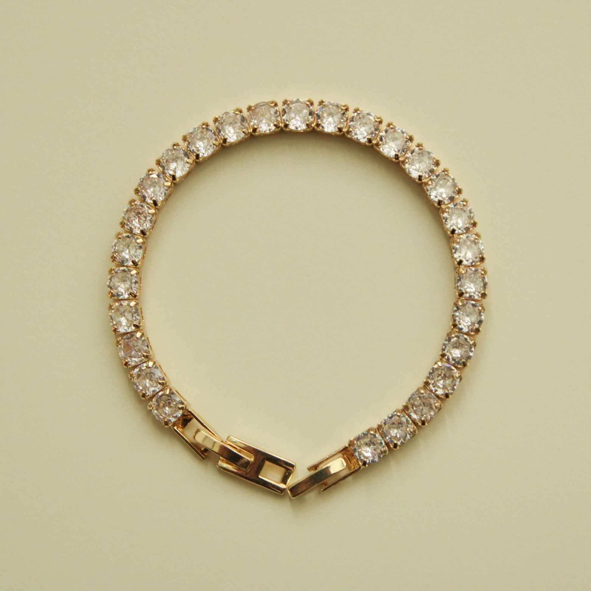 Gold-tone tennis bracelet featuring a continuous circle of clear CZ stones