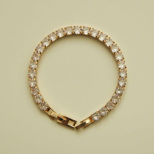 Gold-tone tennis bracelet featuring a continuous circle of clear CZ stones