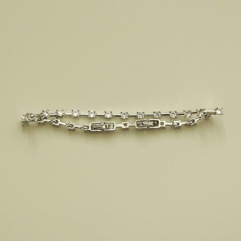 Clear CZ station bracelet laid flat, round clear stones on a silver-tone link chain
