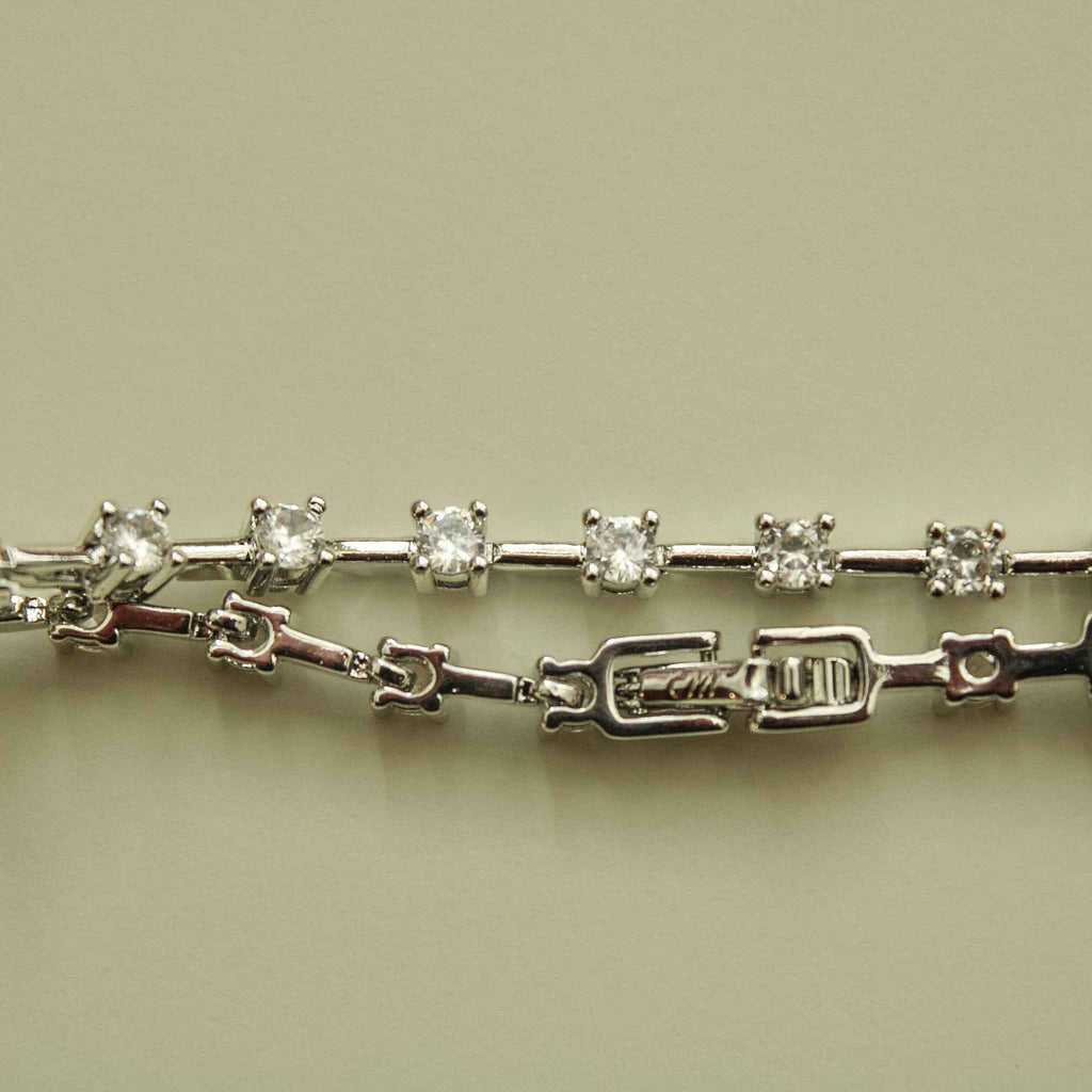 Clear CZ station bracelet side view showing round clear stones, prong stations, and clasp