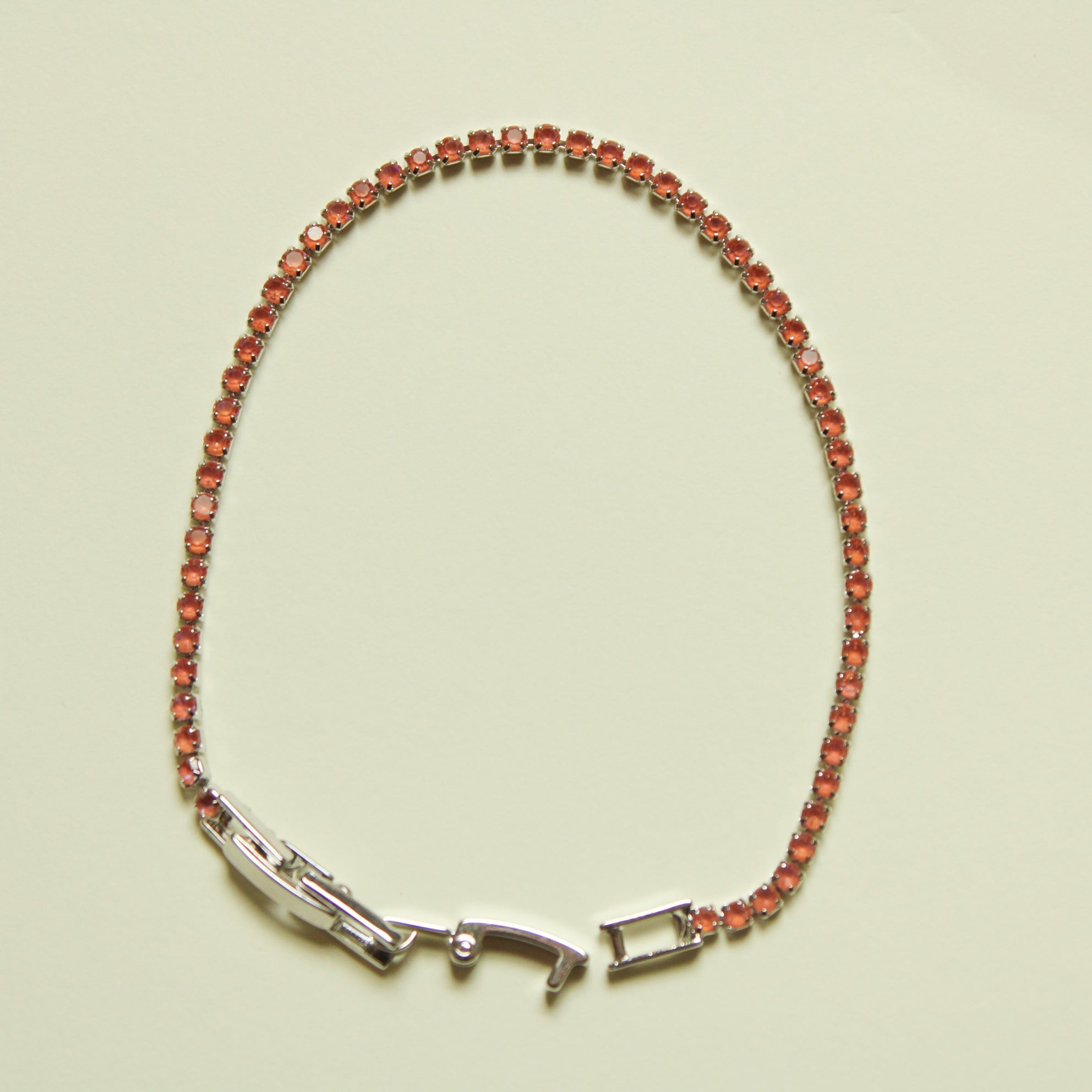 Color-shifting coral tennis bracelet with silver-tone clasp and bezel-set stones