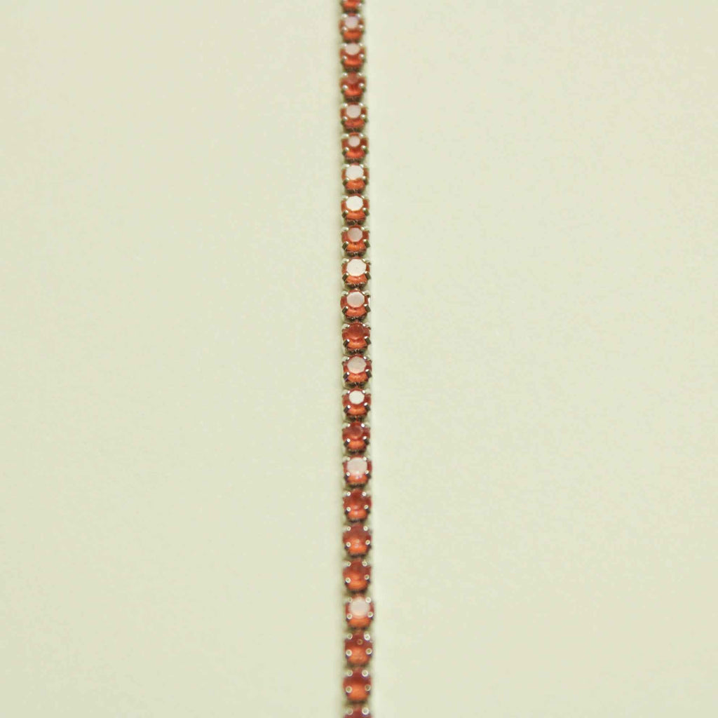 Color-shifting coral tennis bracelet with small round, tennis-set stones in rows