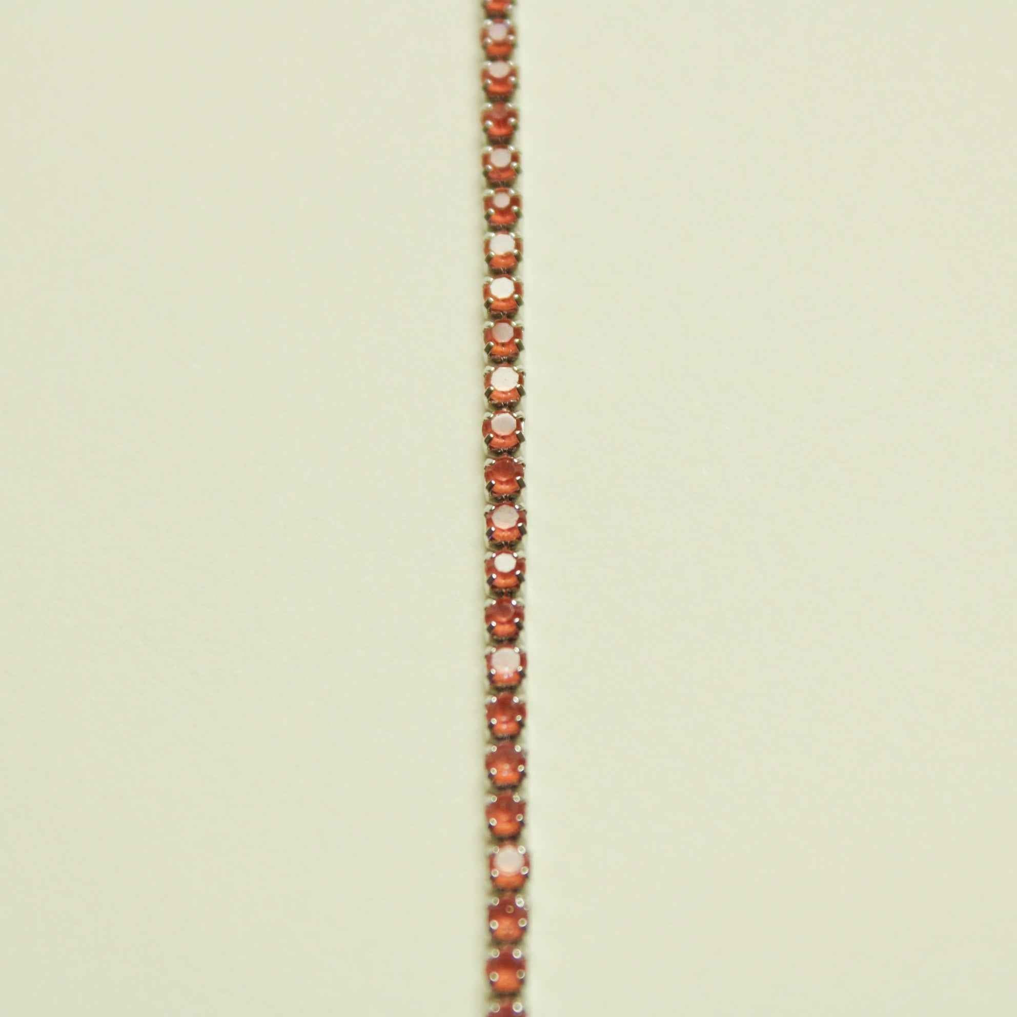 Color-shifting coral tennis bracelet with small round, tennis-set stones in rows
