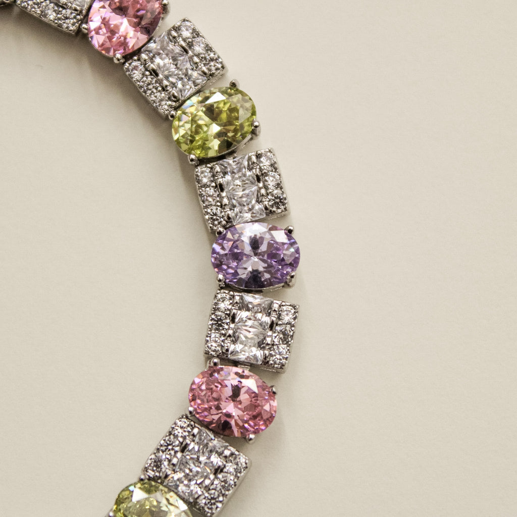 Silver-tone tennis bracelet section with round pink, green, and purple CZ stones