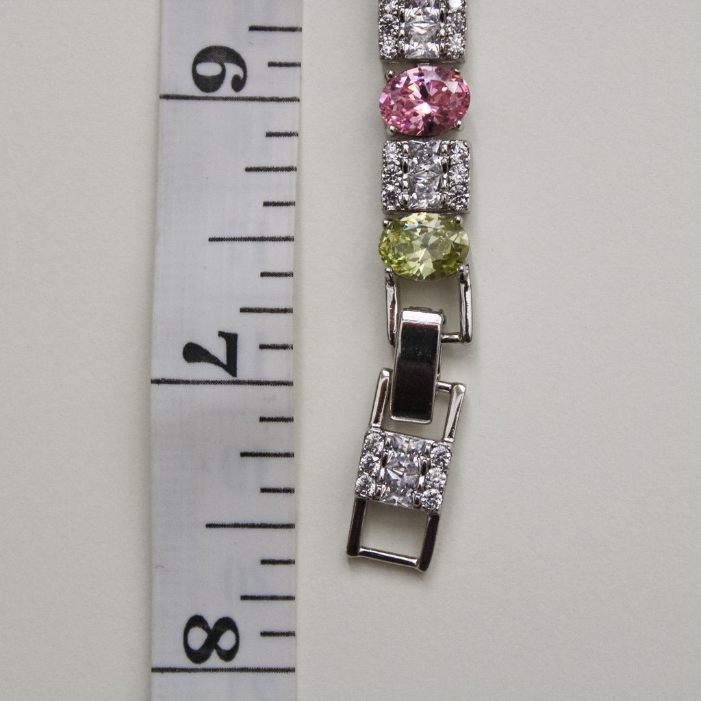 Tennis bracelet side view with hinged clasp and round multicolor stones in square settings