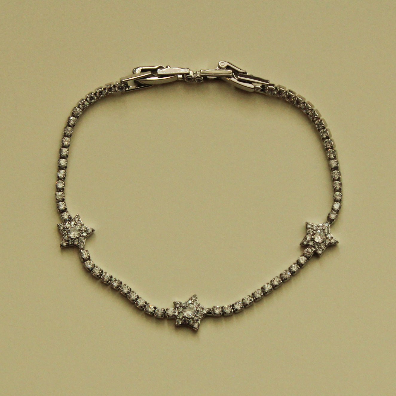 Silver-tone tennis bracelet with three clear CZ star accents and hinged clasp