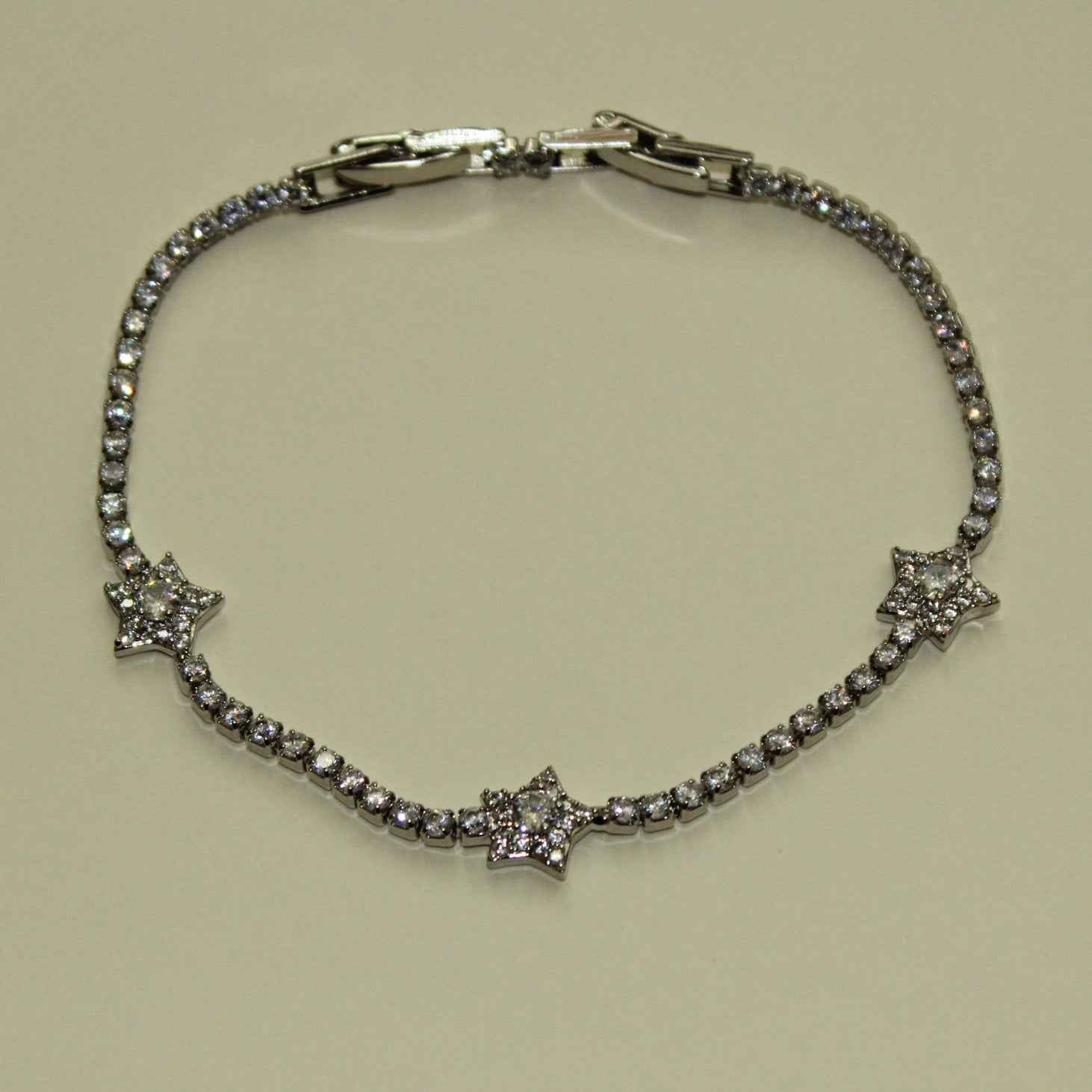 Silver-tone tennis bracelet featuring three clear CZ star accents and stone band