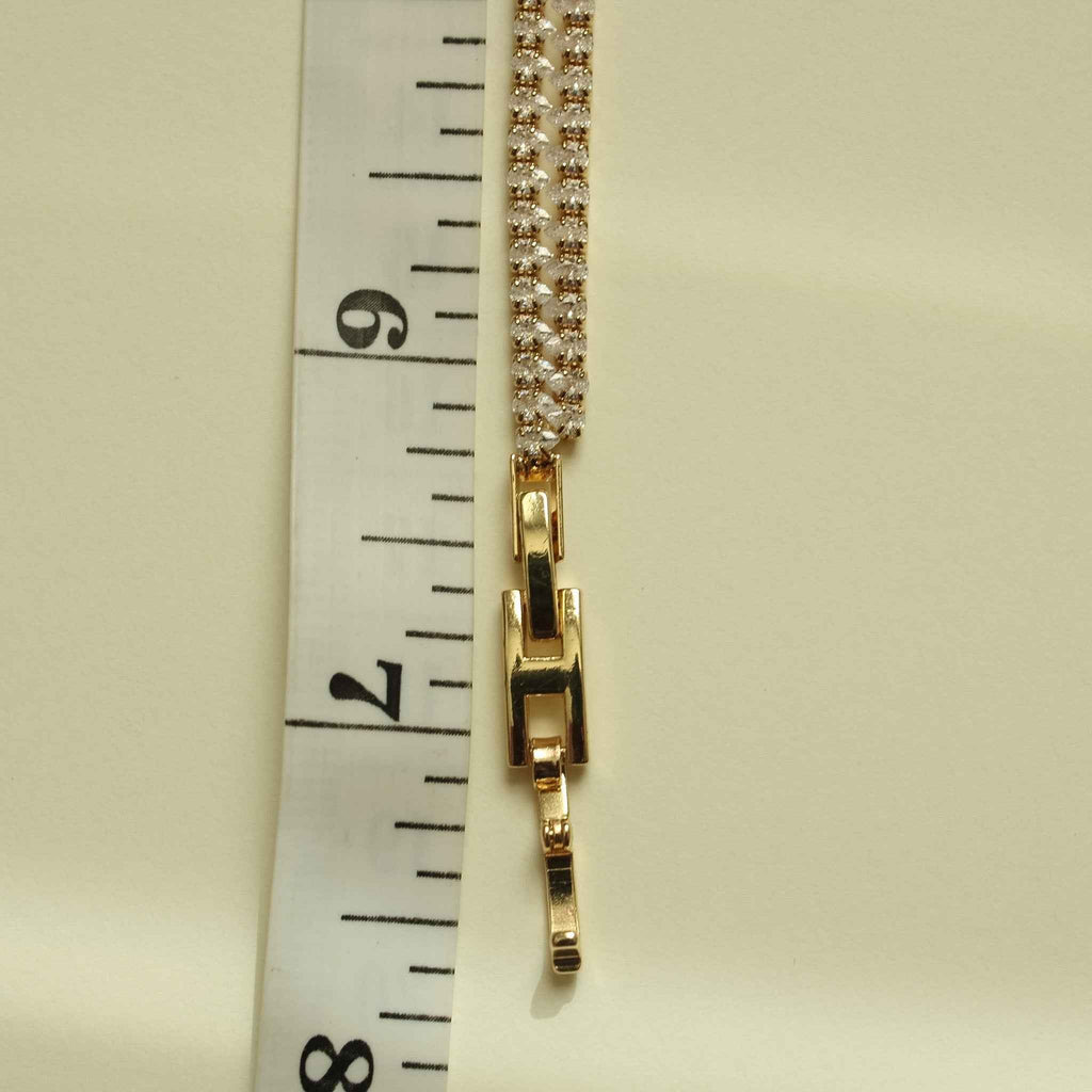 Gold-tone double-row tennis bracelet clasp with clear CZ pavé, side view.