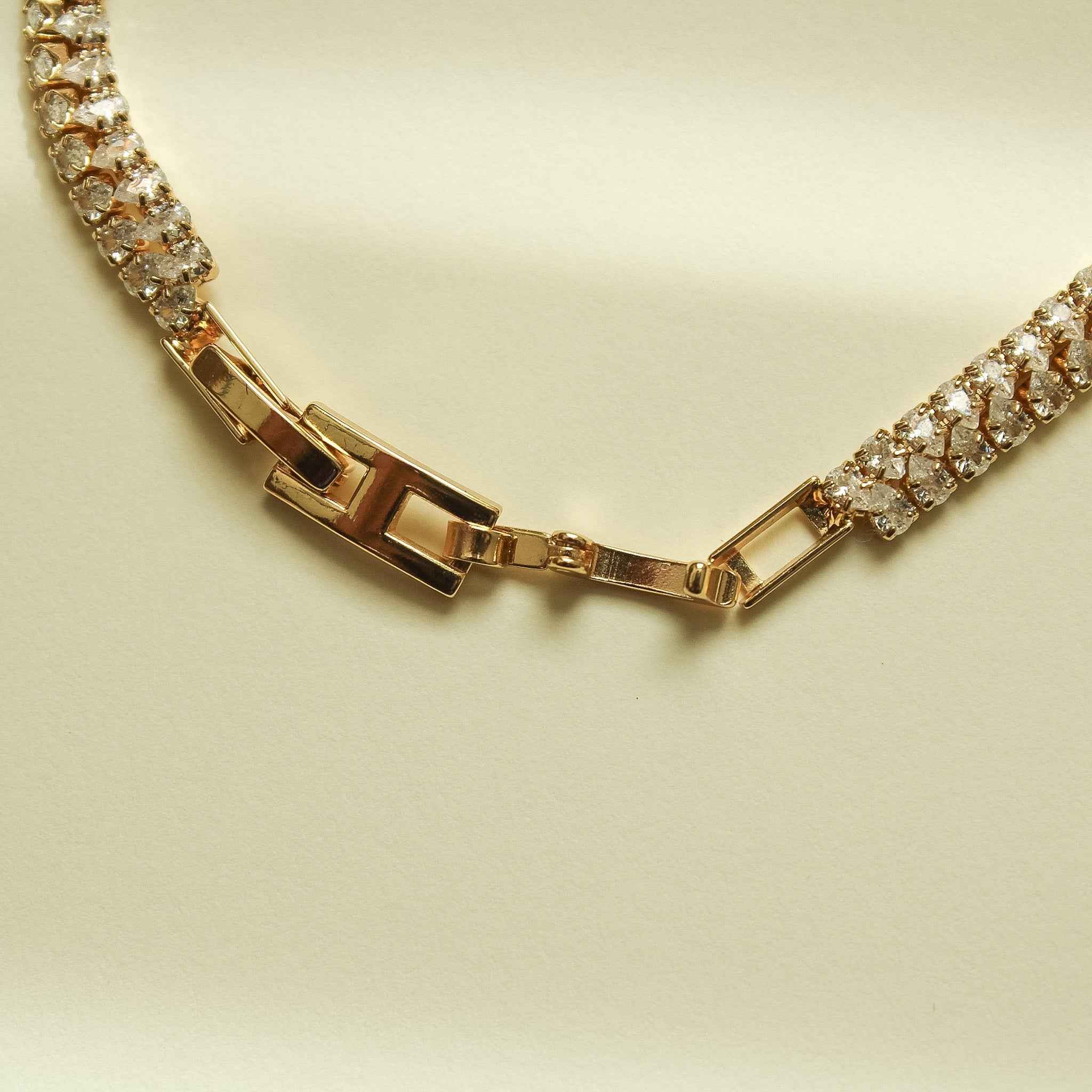 Gold-tone tennis bracelet with two rows of clear CZ stones and hinged box clasp.
