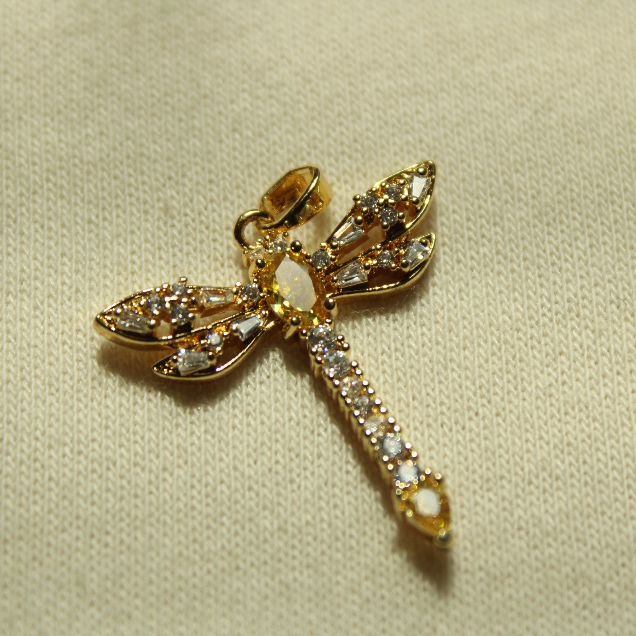 Gold dragonfly pendant with curved wings and yellow teardrop accents