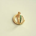 Gold-tone mini huggie hoop earrings, front view with green CZ bar center