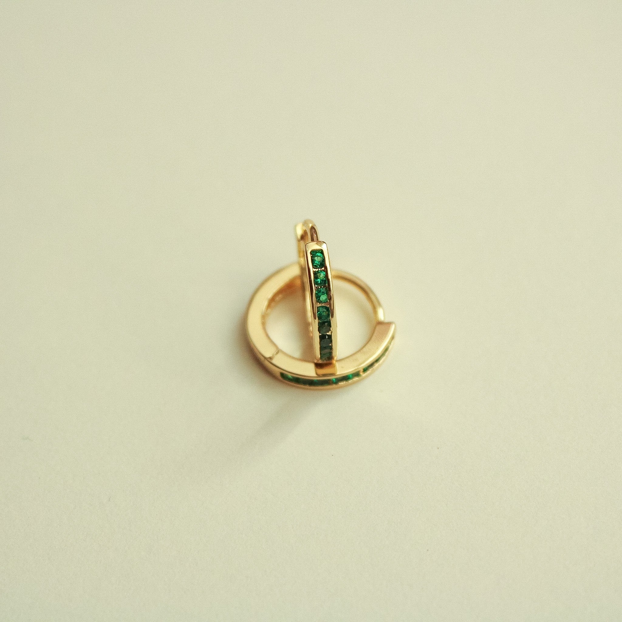 Gold-tone mini huggie hoop earrings with green CZ vertical stone strip