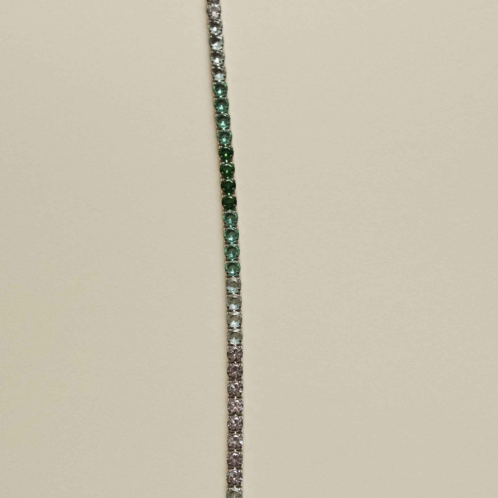 Tennis bracelet with narrow line of small green and clear pavé stones