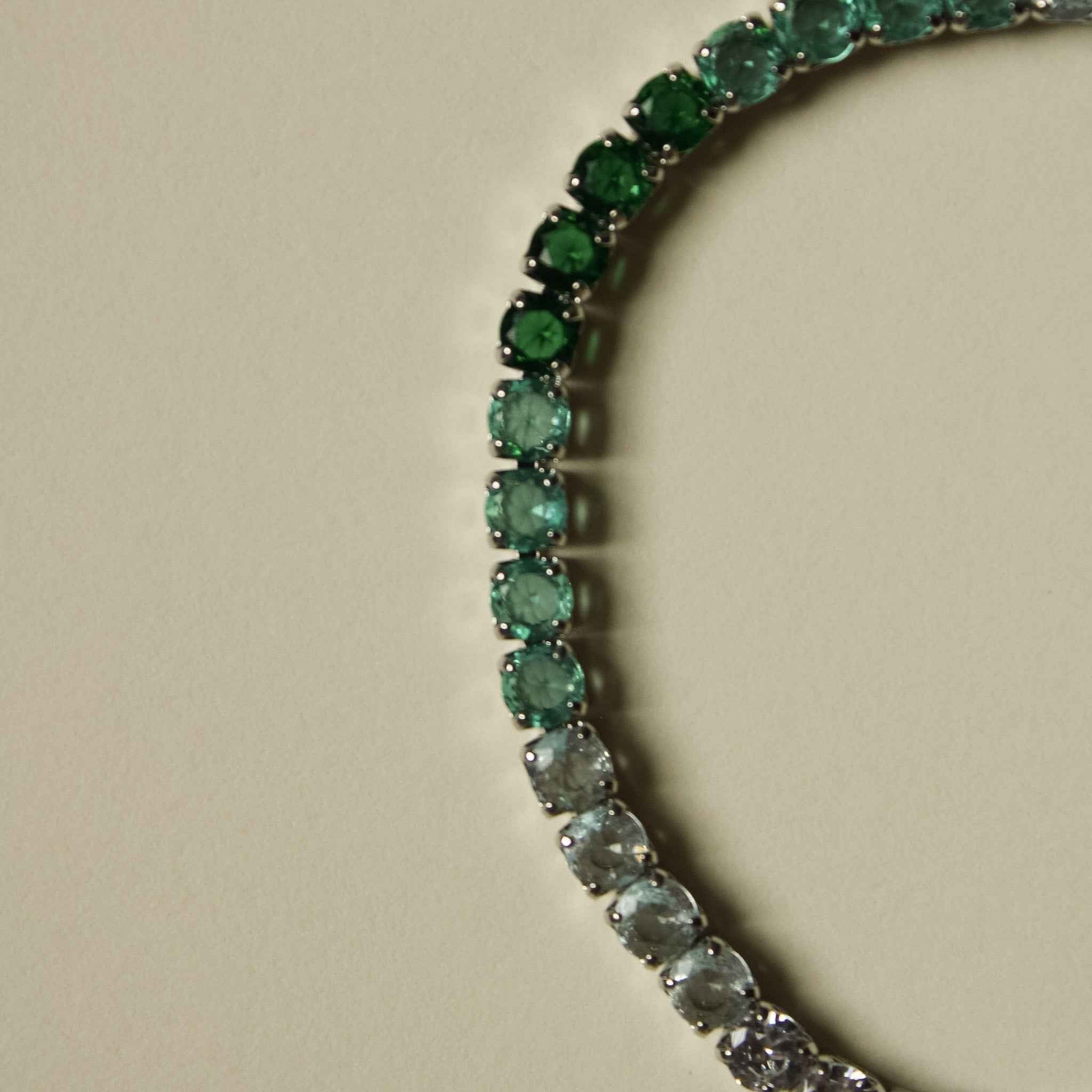 Ombre tennis bracelet with green and clear faceted stones in a row