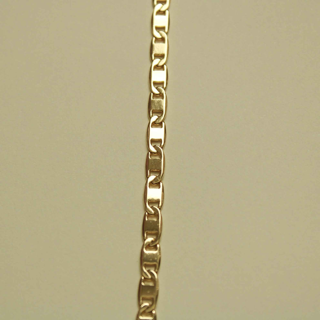 Gold-tone chain bracelet links with smooth polished surfaces; side view.