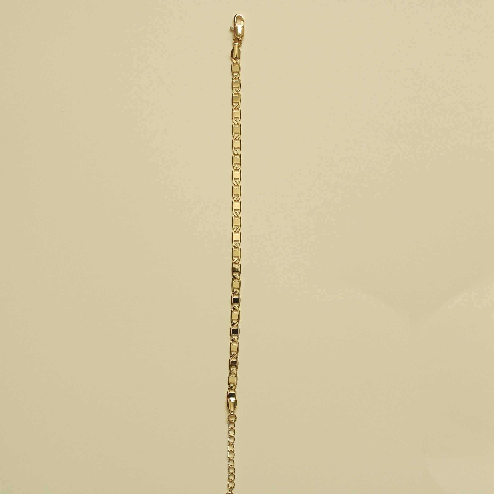 Gold-tone anchor link bracelet hanging straight with small chain links.
