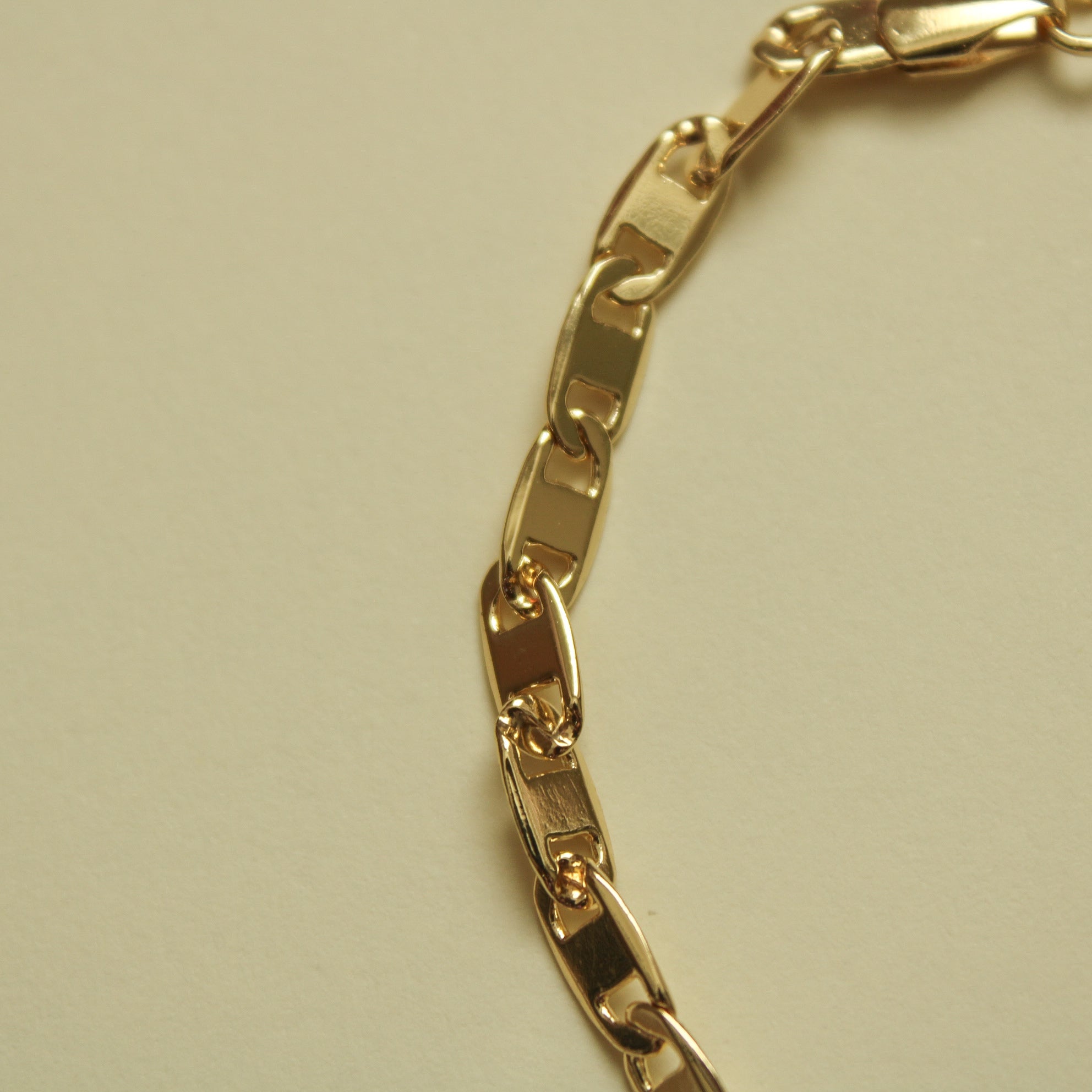 Gold-tone bracelet with wide polished links; side angle close-up.