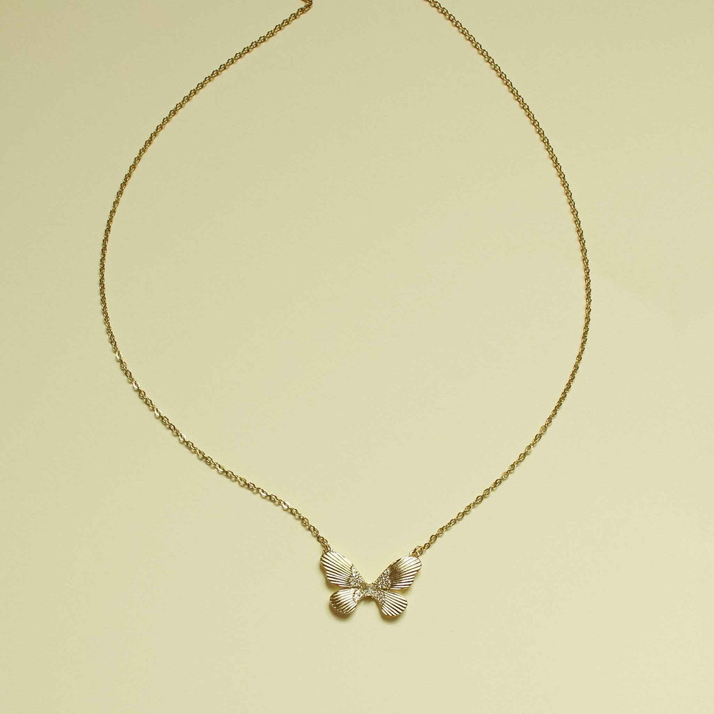 Gold-plated butterfly CZ necklace with fluted bow-like pendant and chain.
