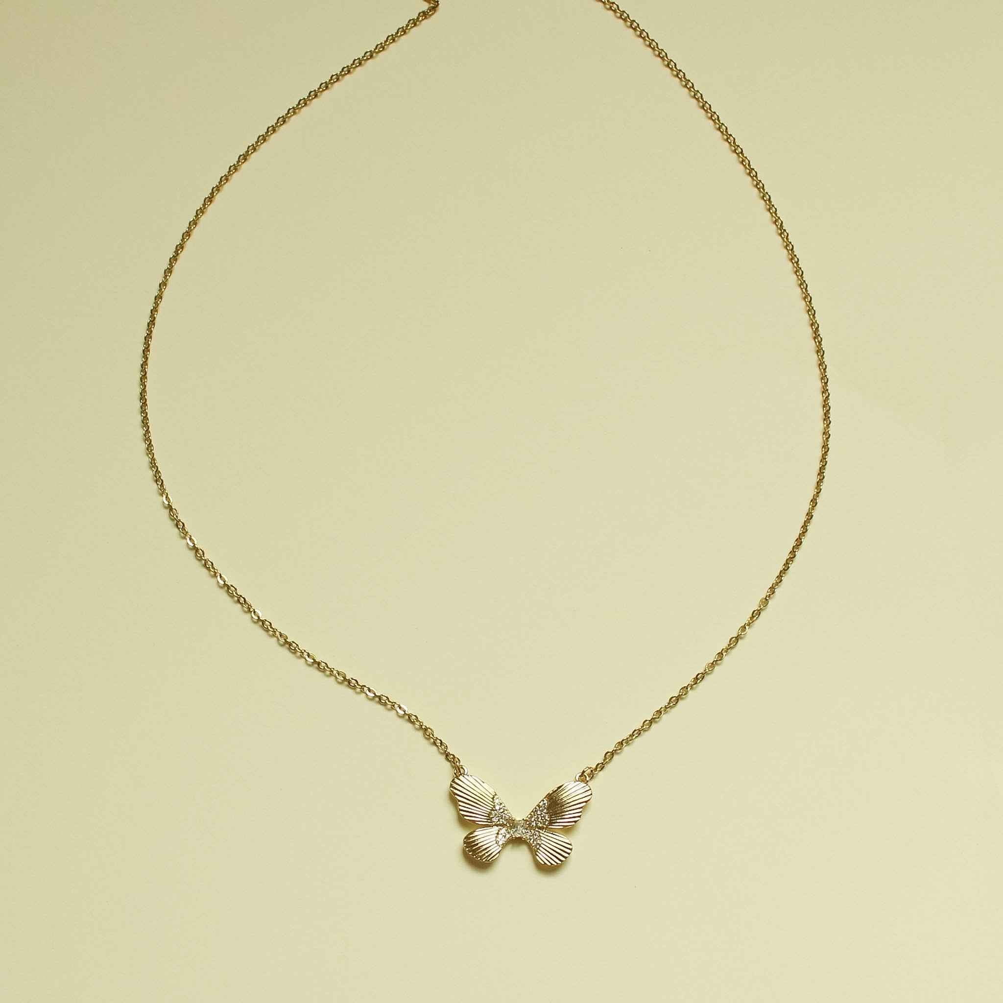 Gold-plated butterfly CZ necklace with fluted bow-like pendant and chain.