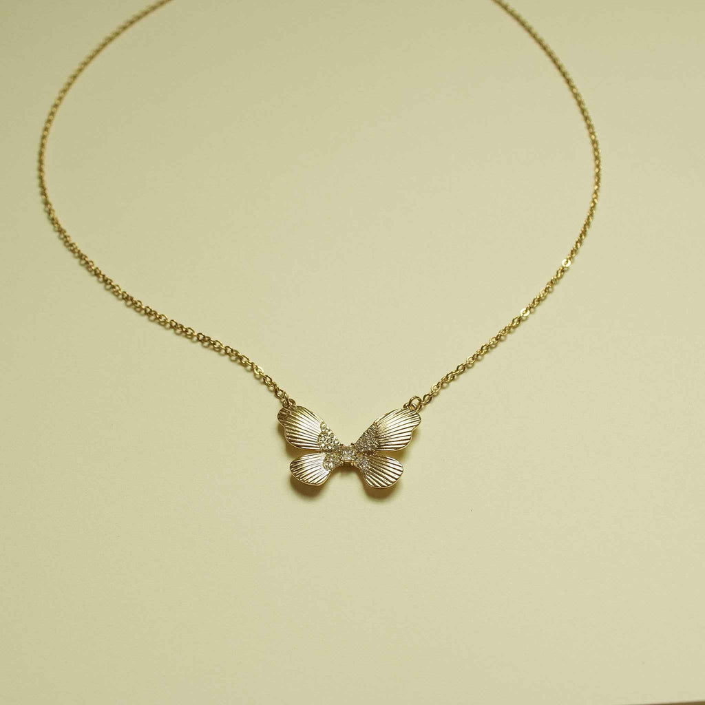 Gold-plated butterfly CZ pendant necklace with three-wing fluted design on chain.
