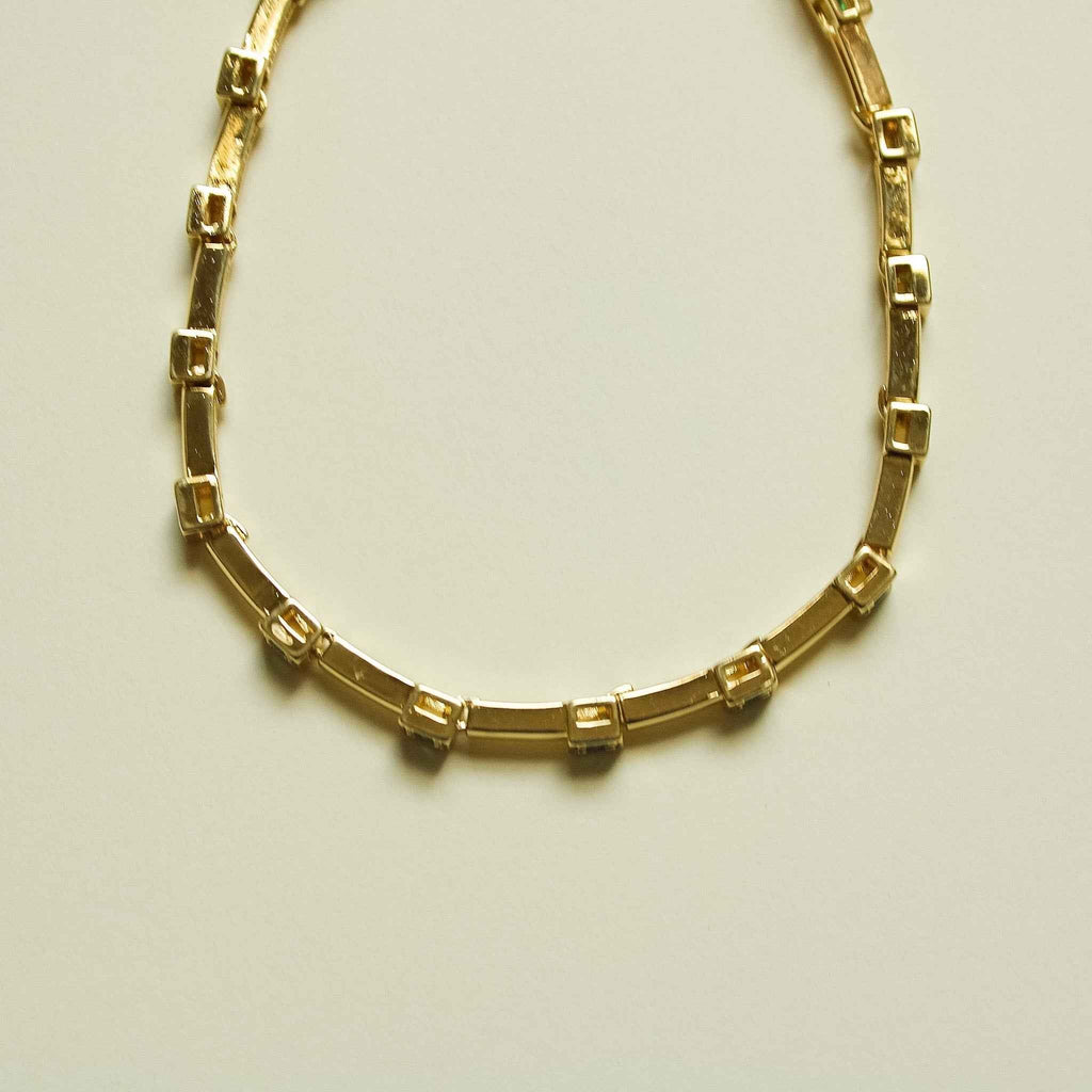 Gold-tone bar link bracelet, side view showing rectangular settings