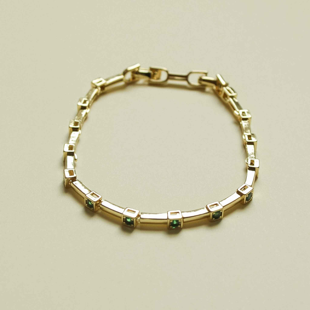 Gold-tone bar link bracelet with small square green accent stones
