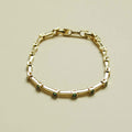 Gold-tone bar link bracelet with small square green accent stones