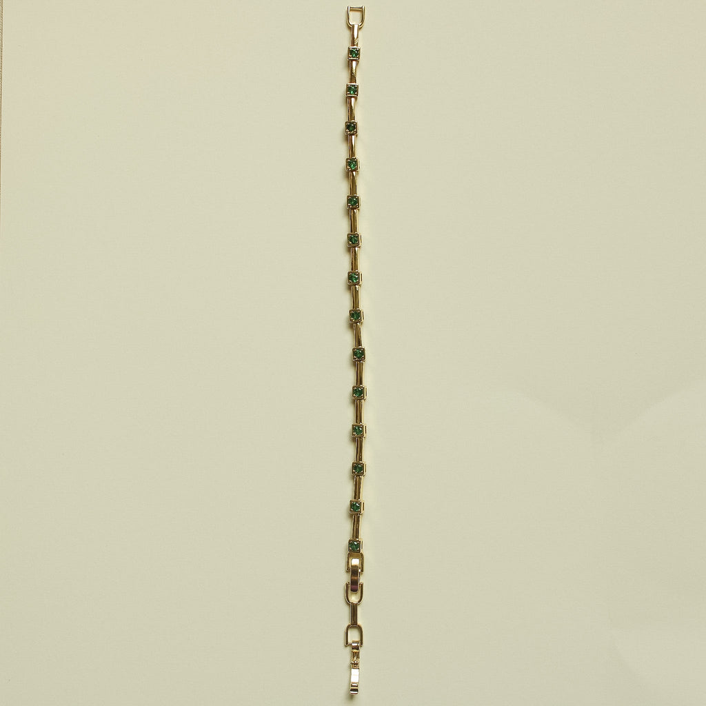 Gold-tone bracelet chain with slim rectangular links and green accents