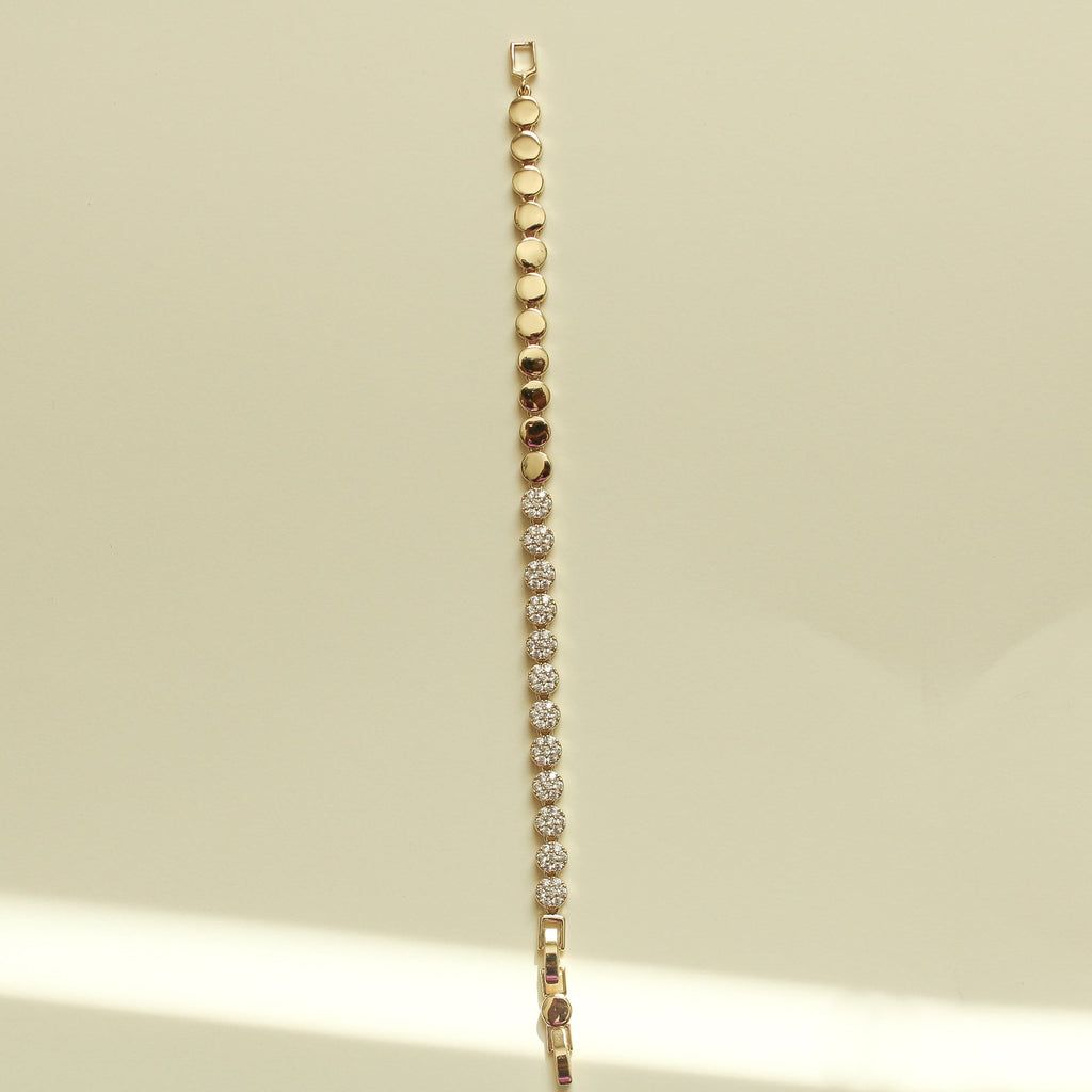 Pavé tennis bracelet with small round stones and gold disc beads along the side.