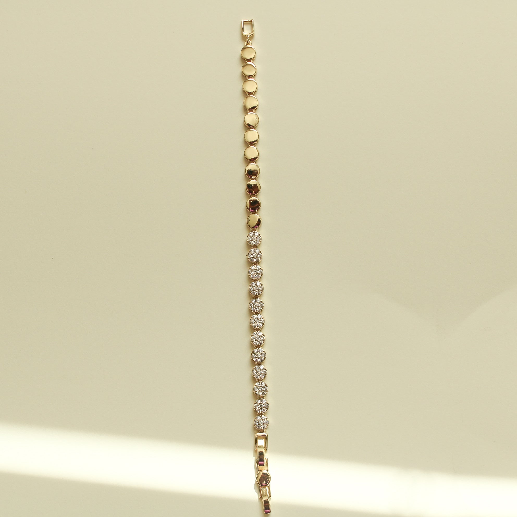 Pavé tennis bracelet with small round stones and gold disc beads along the side.